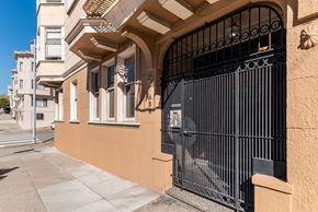 San Francisco apartment for rent - A black gate is in front of a tan building.