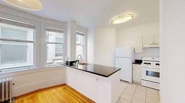 San Francisco apartment for rent - A kitchen with white appliances and wooden floors.