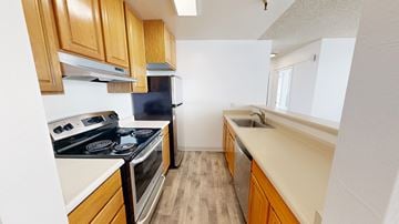 San Francisco apartment for rent - A kitchen with wooden cabinets and a black fridge.