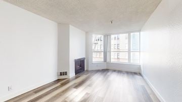 San Francisco apartment for rent - A spacious living room with a fireplace and hardwood floors.
