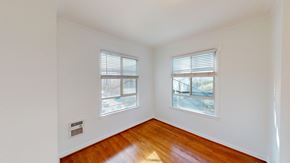 San Francisco apartment for rent - A room with two windows and wooden floors.