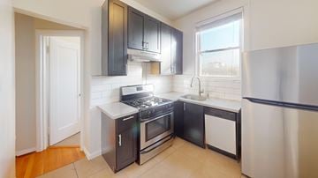 San Francisco apartment for rent - A kitchen with black cabinets and a stainless steel refrigerator.