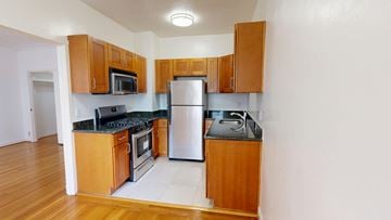 San Francisco apartment for rent - A kitchen with wooden cabinets and a black countertop.