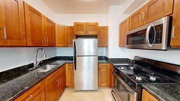 San Francisco apartment for rent - A kitchen with wooden cabinets and a stainless steel refrigerator.