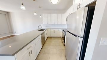 San Francisco apartment for rent - A kitchen with white cabinets and a black refrigerator.