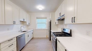 San Francisco apartment for rent - A kitchen with white cabinets and a black stove top oven.