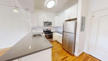 San Francisco apartment for rent - A kitchen with a stainless steel refrigerator and wooden floors.