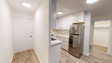 Berkeley apartment for rent - A kitchen with a stainless steel refrigerator and white cabinets.