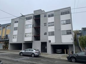 San Francisco apartment for rent - A grey and white apartment building with cars parked in front.