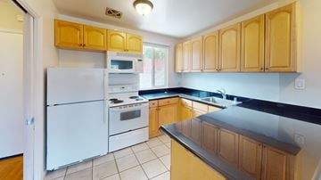 San Francisco apartment for rent - A kitchen with wooden cabinets and a black countertop.