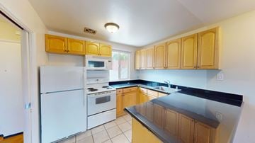 San Francisco apartment for rent - A kitchen with white appliances and wooden cabinets.