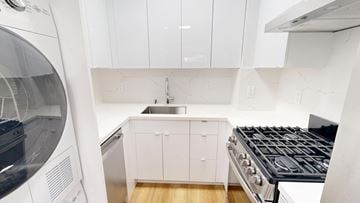 San Francisco apartment for rent - A modern kitchen with white cabinets and a black stove top.