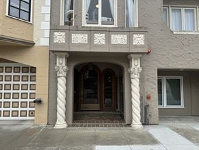 San Francisco apartment for rent - A building with a brown and white facade has a large arched doorway.
