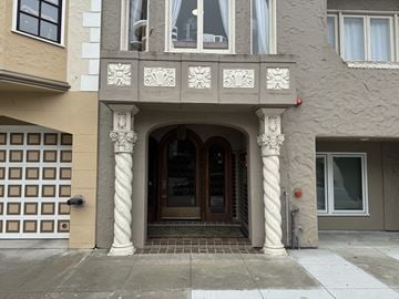San Francisco apartment for rent - A building with a brown and white facade has a large arched doorway.