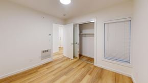 San Francisco apartment for rent - A room with a wooden floor and a white wall with a door and a window.