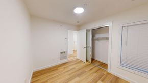 San Francisco apartment for rent - A room with a wooden floor and a white wall with a doorway leading to another room.