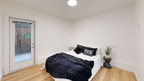 San Francisco apartment for rent - A bedroom with a bed, pillows, and a plant.