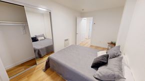 San Francisco apartment for rent - A bedroom with a bed and a mirror on the wall.