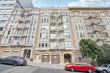 San Francisco apartment for rent - A red car is parked in front of a building with a fire escape.