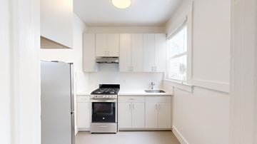 San Francisco apartment for rent - A kitchen with white cabinets and a stainless steel refrigerator.