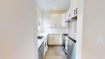 San Francisco apartment for rent - A kitchen with white cabinets and a stainless steel refrigerator.