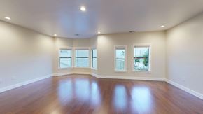 San Francisco apartment for rent - A large empty room with wooden floors and three windows.