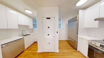 San Francisco apartment for rent - A kitchen with white cabinets and a wooden floor.
