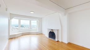 San Francisco apartment for rent - A white room with a fireplace and a window overlooking the beach.