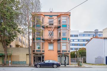 San Francisco apartment for rent - A black car is parked in front of a multi-story building.