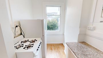 San Francisco apartment for rent - A white gas stove in a kitchen with a window.