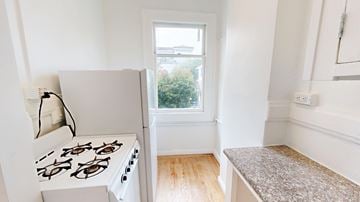 San Francisco apartment for rent - A white stove is in a kitchen with a window.