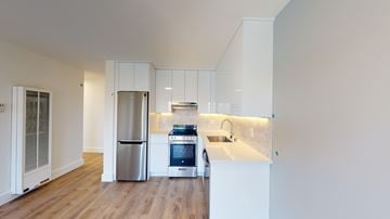 Berkeley apartment for rent - A kitchen with white cabinets and a wooden floor.