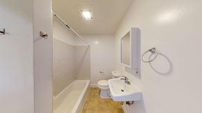 Berkeley apartment for rent - A white bathroom with a tub, toilet, and sink.