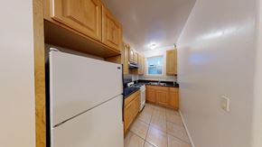 Berkeley apartment for rent - A kitchen with a white refrigerator and wooden cabinets.