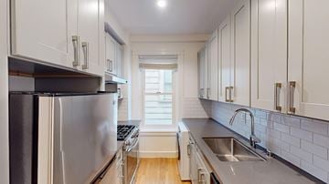 San Francisco apartment for rent - A kitchen with white cabinets and a stainless steel refrigerator.