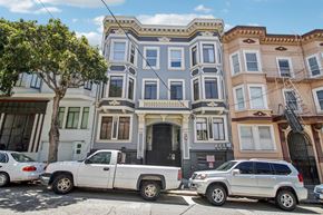 San Francisco apartment for rent - A row of colorful houses with cars parked in front.