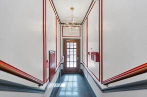 San Francisco apartment for rent - A hallway with a chandelier and a door at the end.