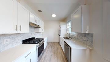 Berkeley apartment for rent - A kitchen with white cabinets and a black stove top.