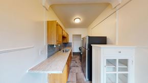 Berkeley apartment for rent - A kitchen with a black refrigerator and wooden cabinets.