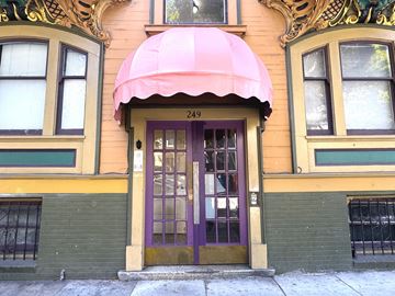 Sanfrancisco apartment for rent - The building has a purple door and a pink awning.