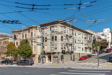 San Francisco apartment for rent - A street view of a city with cars, buildings, and a tram overhead.