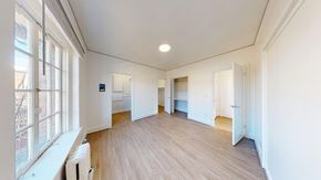 Berkeley apartment for rent - A spacious room with wooden floors and white walls.