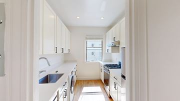San Francisco apartment for rent - A modern kitchen with white cabinets and appliances.