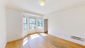 San Francisco apartment for rent - A room with wooden floors and a window overlooking a cityscape.