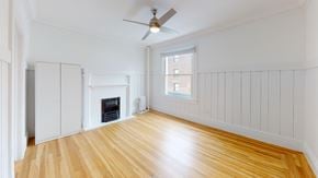 Berkeley apartment for rent - A room with a fireplace and a ceiling fan.