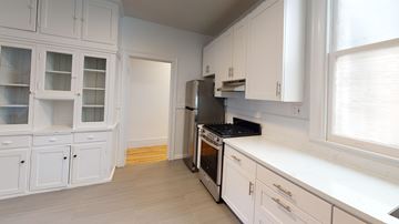 Berkeley apartment for rent - A kitchen with white cabinets and a black stove top oven.