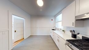 Berkeley apartment for rent - A kitchen with white cabinets and a black stove top.