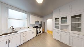 Berkeley apartment for rent - A kitchen with white cabinets and a black fridge.