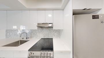 Berkeley apartment for rent - A modern kitchen with a white countertop and a black stove top.