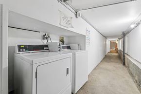 San Francisco apartment for rent - A long white hallway with a washing machine on the left.